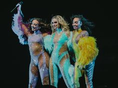 three women dressed in colorful costumes on stage