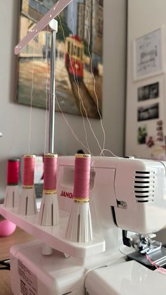 the sewing machine has three pink spools on it