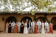 a group of people standing next to each other in front of a building with trees