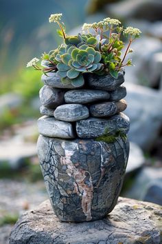 a stack of rocks with succulents and moss growing out of it on top