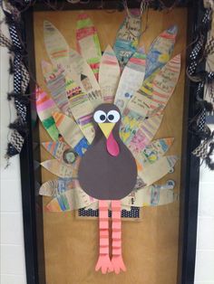 a turkey made out of newspaper strips on a bulletin board in front of a door