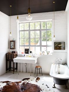 the bathroom is decorated in white and has an antique claw foot bathtub, sink, and mirror