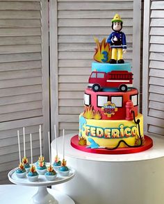 a birthday cake with cupcakes in the shape of cars and firetrucks