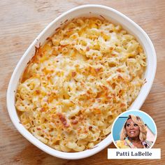 a white bowl filled with macaroni and cheese on top of a wooden table