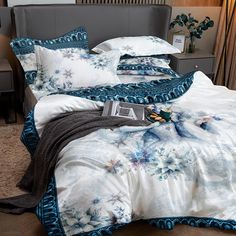 a bed with blue and white comforters on top of it