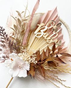 an arrangement of flowers and feathers on a white surface