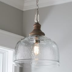 a glass light fixture hanging from a ceiling in a room with gray walls and white trim