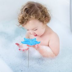 a baby playing with a toy in the bathtub