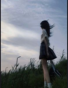 a woman standing on top of a lush green field