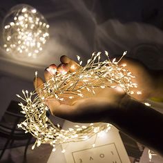 a person is holding some lights in their hand while they are sitting on a table