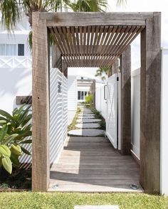 a wooden walkway leading to a white house with palm trees in the foreground and text overlay that reads, walking