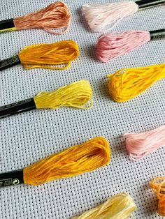 several skeins of yarn laid out on a table with crochet hooks