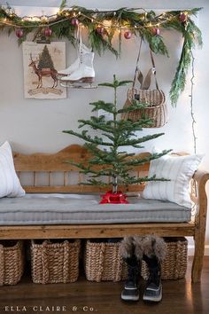 a wooden bench with baskets underneath it and a christmas tree