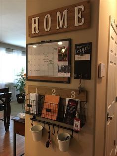 a wall mounted calendar and coffee cups on a shelf in front of a kitchen door