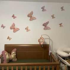 a baby's crib with pink butterflies on the wall