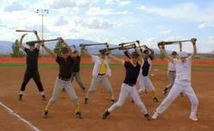 a group of young men standing on top of a baseball field holding up their bats