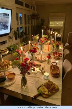 a long table is set with food and candles