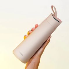 a woman's hand holding a white tumbler bottle