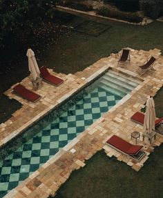 an aerial view of a pool with lounge chairs and umbrellas