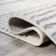 a close up of a rug on the ground with wood flooring in the background