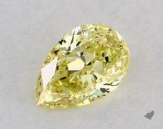 a fancy yellow diamond on a white surface