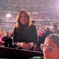 a woman sitting in the stands at a sporting event