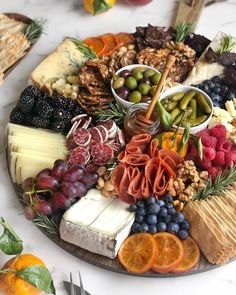 a platter filled with cheese, fruit and crackers