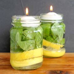 two mason jars filled with lemon slices and spinach leaves