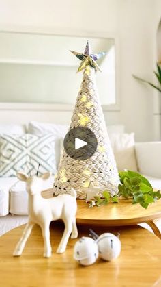 a christmas tree sitting on top of a wooden table next to two white deer figurines