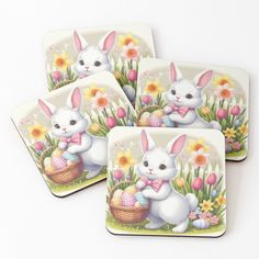 four coasters with an image of a bunny holding a basket full of easter eggs