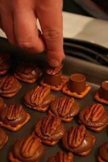 a person is placing chocolate on top of small cupcakes