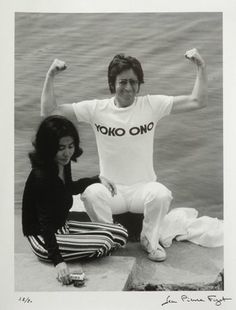 the man and woman are posing for a photo by the water with their arms in the air