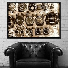 a black leather chair sitting in front of a white brick wall with clocks on it