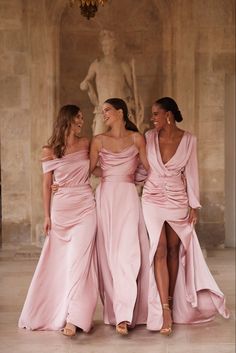 three women in pink dresses standing next to each other