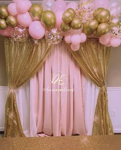 the balloon arch is decorated with gold and pink balloons