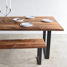 a wooden table with plates and candles on it