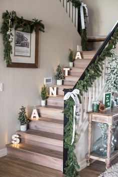 christmas decorations on the banisters and stairs in a home decorated with greenery