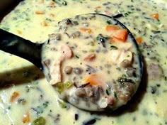 a ladle filled with soup sitting on top of a table