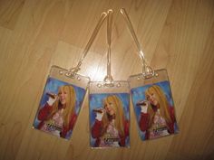 two tags with pictures of the same woman on them hanging from a wooden table top