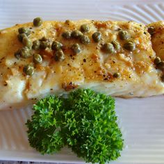 a white plate topped with fish and broccoli