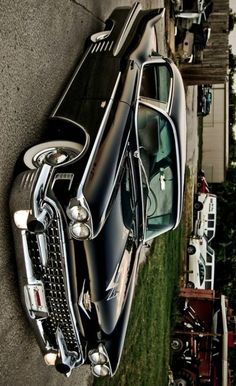 an old black car parked next to a building