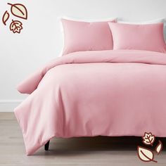 a bed with pink sheets and pillows on it