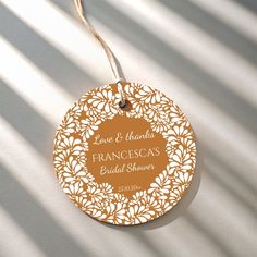 an orange and white wedding ornament hanging from a string with the words love & thanks francesca's bridal shower on it