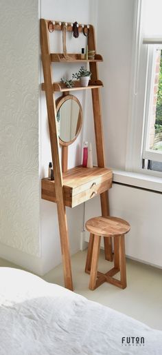 a wooden ladder is next to a mirror and stool in a room with white walls