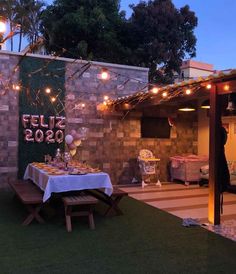 an outdoor dining area with lights strung from the roof and tables set up for dinner