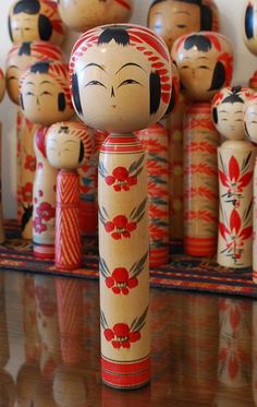 a group of wooden dolls sitting on top of a table