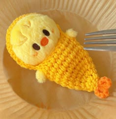 a yellow stuffed animal laying on top of a paper plate with a fork in it