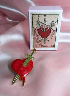 a red heart shaped keychain sitting next to a card