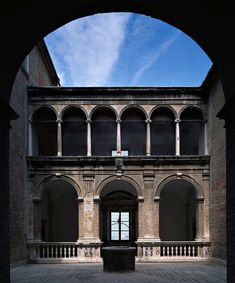 an arched doorway leading into a building with columns and arches