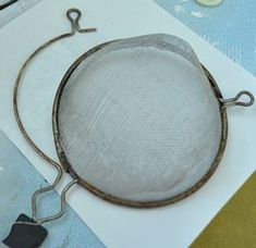 a wire mesh strainer sitting on top of a piece of paper